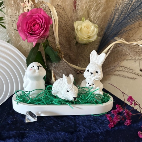 Häschen,  Kaninchen und Häsin mit Baby auf einem Tablett. Ostern