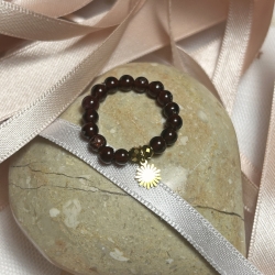 Schöner, elastischer Ring mit Granatsteinen und Sonnenanhänger.