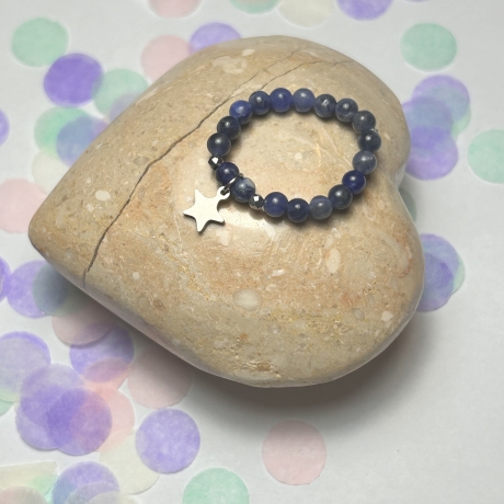 Flexibler Ring aus blauem Achat mit Sternanhänger.