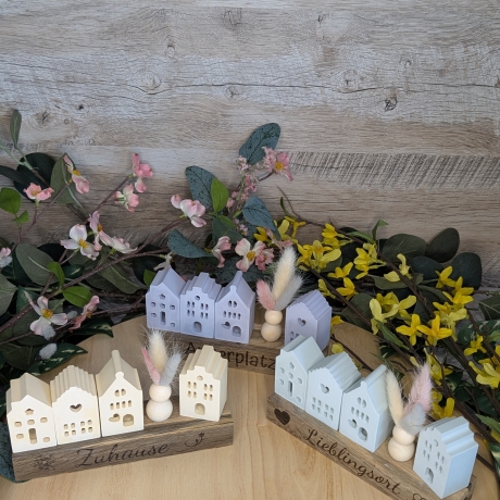 Lichthäuser mit Trockenblumen auf Holz