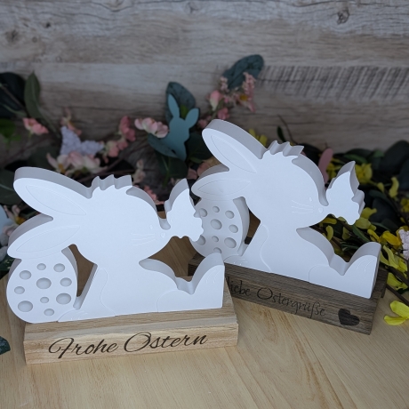süßer Hase mit Schmetterling mit einem Ostergruß auf Holz