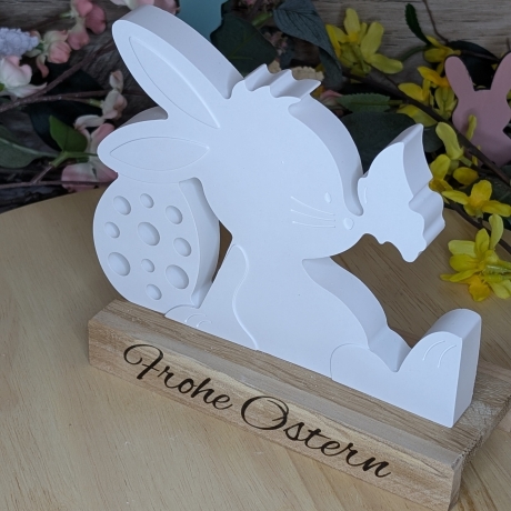 süßer Hase mit Schmetterling mit einem Ostergruß auf Holz