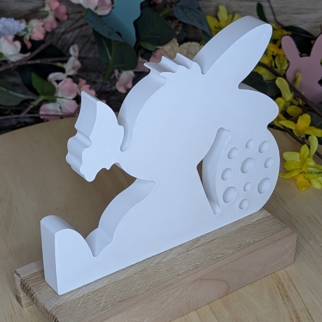 süßer Hase mit Schmetterling mit einem Ostergruß auf Holz