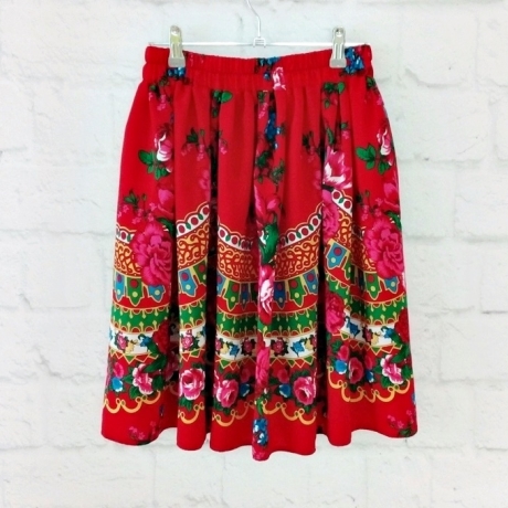 Stoff mit Blumenmuster auf rotem Hintergrund