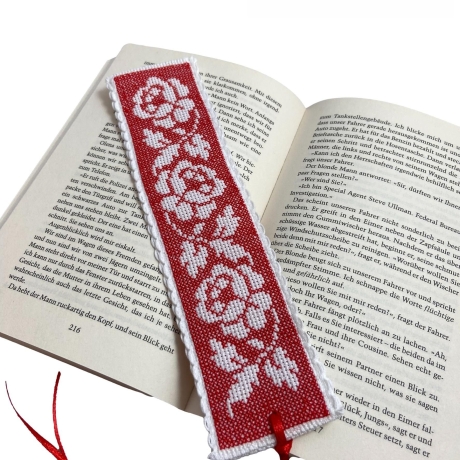 Gesticktes Lesezeichen mit Rosen auf rotem Hintergrund