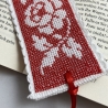 Gesticktes Lesezeichen mit Rosen auf rotem Hintergrund