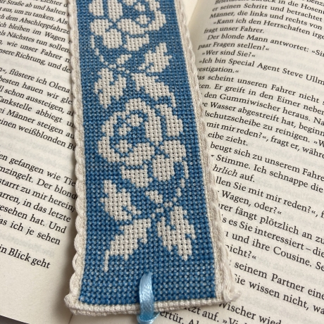 Gesticktes Lesezeichen mit Rosen auf blauem Hintergrund