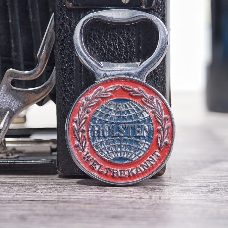 Flaschenöffner Holsten weltbekannt: In jeder Lage, 7 x 4 cm, Metall, mit schöner Alterspatina