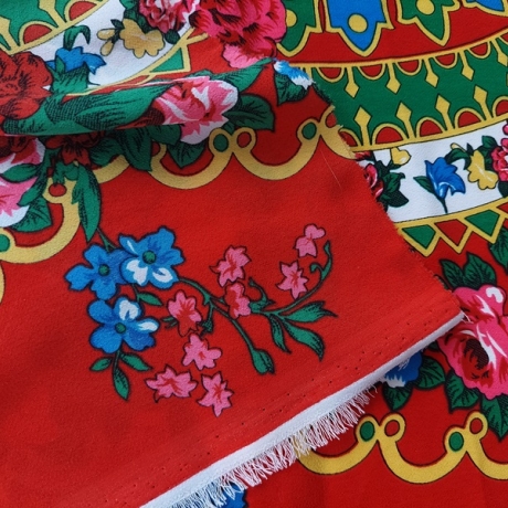 Stoff mit Blumenmuster auf rotem Hintergrund
